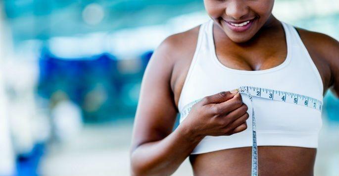 Woman measuring breasts with measuring tape