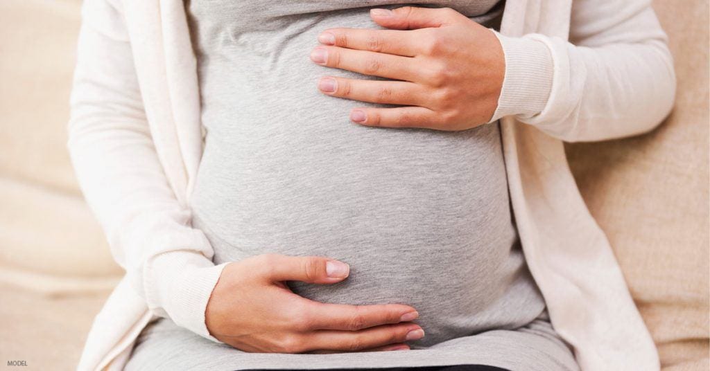 Pregnant woman contemplating a tummy tuck during a C-section