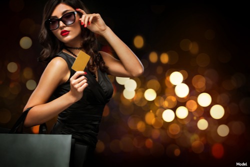 Model holding gold card wearing sunglasses